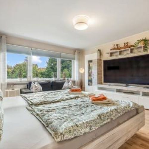 Liebevoll dekoriertes Schlafzimmer mit hochwertigen Kissen und Decken im Paisley-Design für maximalen Komfort in Ihrem Urlaub.