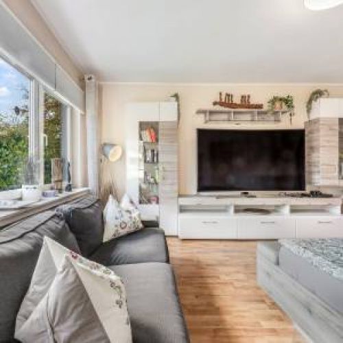 Rundum versorgt: Modern eingerichtetes Zimmer für Familien und Teams mit Zugang zur voll ausgestatteten Küche und dem Balkon mit Blick ins Grüne.