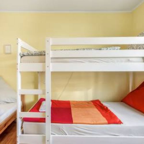 Gemütliches Dreibettzimmer mit Leselampen an jedem Bett und blickdichten Rollos für maximale Privatsphäre und Erholung im Ammerland.