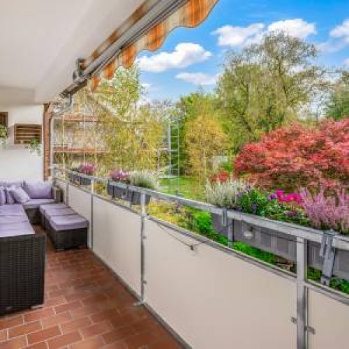 Gemütliche Rattan-Sitzlounge auf dem Balkon mit Blick ins Grüne – genießen Sie laue Sommernächte unter der schützenden Markise in Ihrer Ferienwohnung in Bad Zwischenahn.