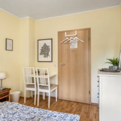 Bewusst abschalten: Gemütliches Doppelbett im kompakten Wohlfühlzimmer – genießen Sie die TV-freie Zone für echte Erholung und einen ungestörten Blick auf den grünen Balkon.